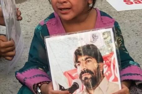 A child holding picture of abducted Dr Deen Mohammad Baloch